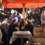 Londoners enjoy a drink in the rain - PA