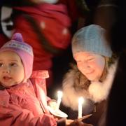 Carollers enjoy traditional service by candlelight at Wimbledon Village stable yard