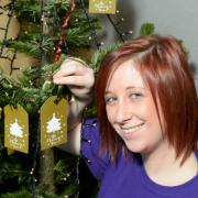 Holly Marshfield, Garden Centre Assistant, putting her memory on the tree.