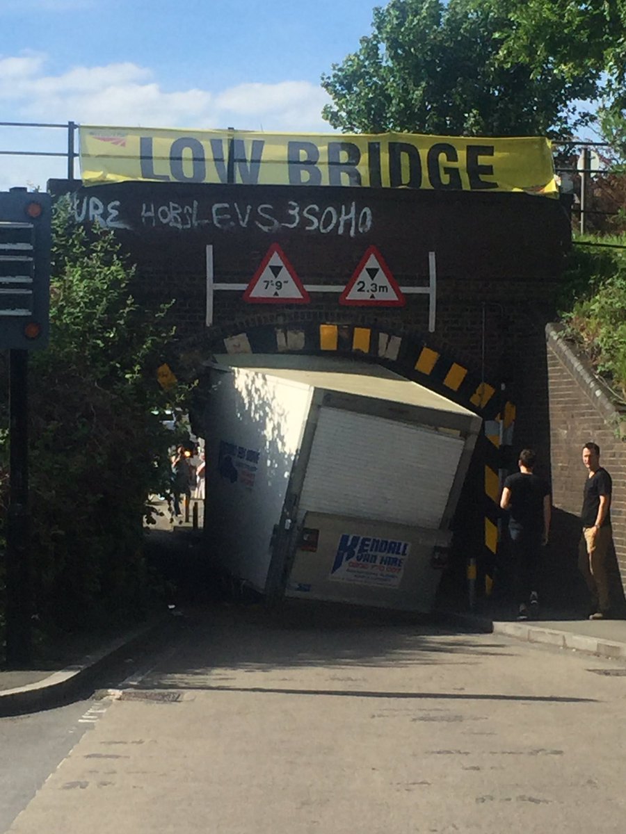 OOPS! Van loses load after getting stuck under low bridge