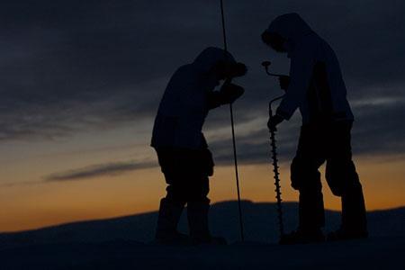 Members of the Catlin Arctic Survey team use an ice drill to take samples of the ice for research