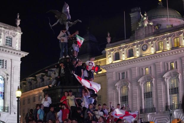 England football fans climb the statue of Eros in Piccadilly Circus, central London, after England beat Ukraine 4-0 in their Euro2020 quarter final match. Image: Victoria Jones/PA Wire.