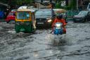 Vehicles move through a waterlogged street in Kolkata, India (Bikas Das/AP)