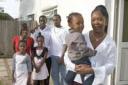 Supermum: Single parent Carol Pinnock  holds her youngest child Jerell while the rest of her family stand proudly behind.