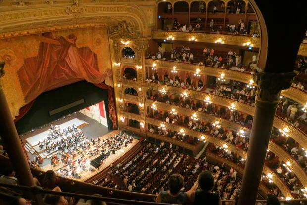 Your Local Guardian: A grand theatre with people watching an orchestra. Credit: Canva