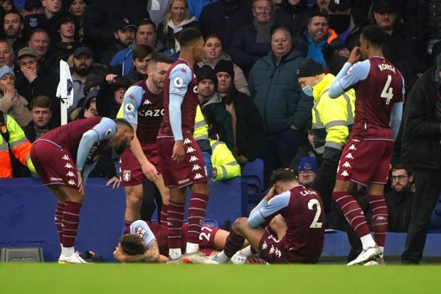 Aston Villa's Lucas Digne, lying down, and Matty Cash, sitting, were hit by objects thrown from the crowd in the game against Everton