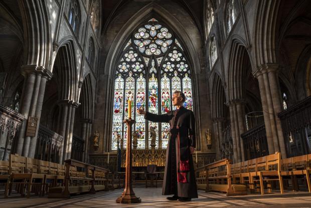 Your Local Guardian: Very Reverend John Dobson Dean of Ripon lights a candle to mark the second anniversary of the first national coronavirus lockdown at Ripon Cathedral, North Yorkshire, ahead of the National Day of Reflection on Wednesday (PA)