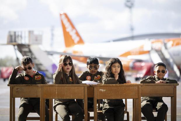 Your Local Guardian: Sam Bennett, aged 12, Olivia Joohee-Riddington, aged 9, Arjun Giri, aged 9, Rei Diec, aged 7 and Rico Jeerasinghe, aged 9 during filming of a parody of the movie Top Gun at Luton airport as part of easyJet's nextGen recruitment campaign. Credit: PA/easyJet