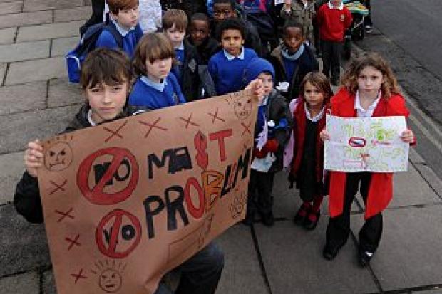 Last-ditch plea: Parents and children gathered at the site of the proposed mast, by the Avondale Road bus station in North Worple way, Mortlake, on Wednesday, to show their determination to bring the plan to a