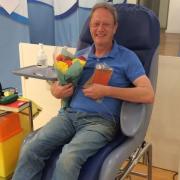 Tony Shaw was greeted with flowers after his 100th blood product donation at Croydon Plasma Donor Centre on his 64th birthday