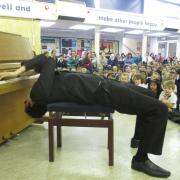 Aaron plays the piano backwards to the delight of the children