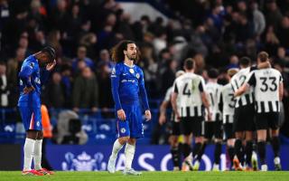 Chelsea's Jorrel Hato (left) and Marc Cucurella looks dejected as Newcastle United players celebrate victory following the Premier League match at Stamford Bridge, London